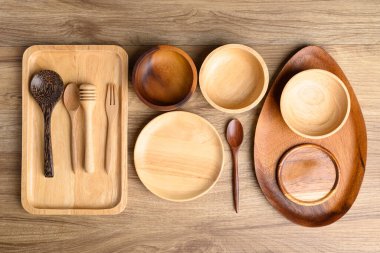 Mutfak gereçleri, ahşap kase, tabak, tabak, kaşık ve çatal ahşap zemin üzerinde.