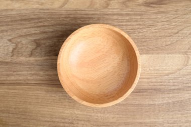 Ahşap arka planda ahşap bir kase, masa üstü manzaralı.