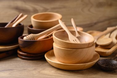 Mutfak gereçleri, ahşap kase, tabak ve kaşık ahşap arka planda.