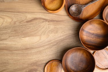 Mutfak gereçleri, ahşap kase, tabak ve ahşap arka planda bardak altlıkları, masa üstü manzarası.