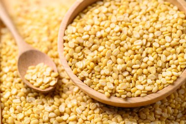 Sarı soyulmuş kuru fasulye, ahşap kasede kaşık, yiyecek malzemesi.