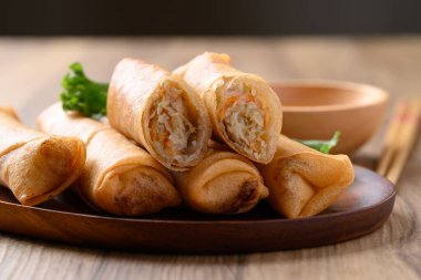 Kabak, havuç ve cam erişteyle doldurulmuş Asya usulü kızarmış börek ahşap zemin üzerinde sos ile yenir.