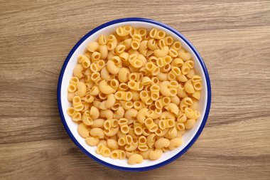 Ahşap zemin üzerinde hamur makarna, yemek malzemesi, masa üstü görünümü.