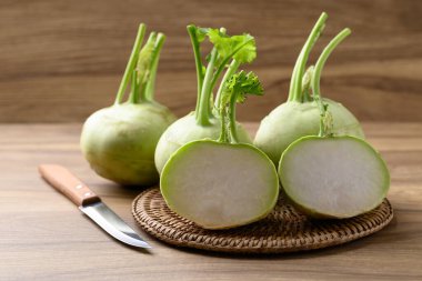 Kohlrabi ya da ahşap arka planda turp lahanası, hem çiğ hem de pişmiş yenilebilir sebze.