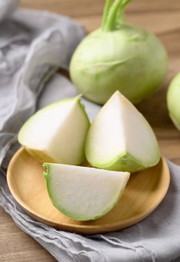 Kohlrabi ya da ahşap arka planda turp lahanası, hem çiğ hem de pişmiş yenilebilir sebze.