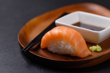 Ahşap tabakta Nigiri suşi somonu, wasabi sosu ve Japon yemeği.