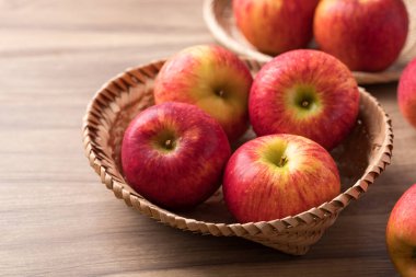 Ahşap zemin üzerinde kırmızı elma (kıskanç elma) sepeti