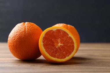 Caracara göbek portakal meyvesi ahşap masa üzerinde siyah arkaplan