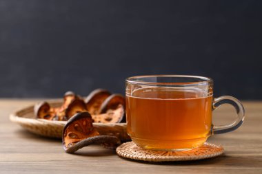 Bael meyveli bitkisel içecek bardakta, ahşap arka planda, sağlıklı içecek.