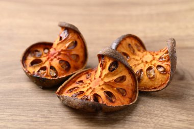 Ahşap arka planda kurutulmuş Bael meyvesi, bitkisel içecek malzemesi.