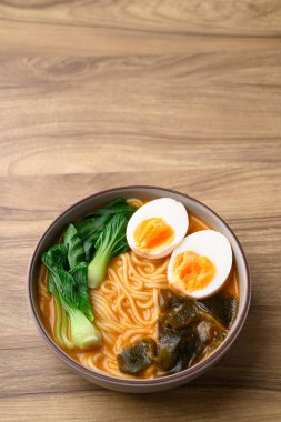 Yumurtalı baharatlı şehriye çorbası, yosun ve kase içinde bok çuvalı, Asya eriştesi tarzı.