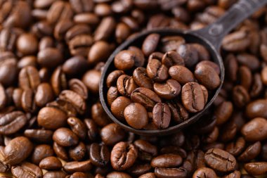 Kavrulmuş kahve çekirdeği (Arabica kahvesi) ve kavrulmuş kahve arkaplanı.