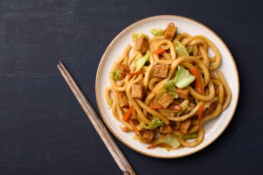 Yaki Udon, kızarmış udon eriştesi ile tofu, havuç, lahana ve mantar, Japon mutfağı, Asya vejetaryen yemeği.