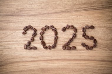 2025 yılbaşı, ahşap arka planda kavrulmuş kahve çekirdeğinden yapıldı.
