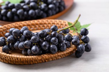 Black grapes in basket on white table, Seedless grapes clipart