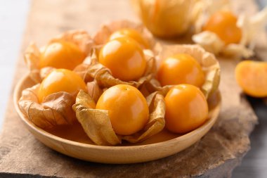 Cape gooseberry or Golden berry (Physalis peruviana) in wooden bowl, Healthy fruit clipart