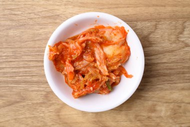 Ahşap arka planda kimchi lahana, Kore yemeği mezesi, masa üstü manzarası.