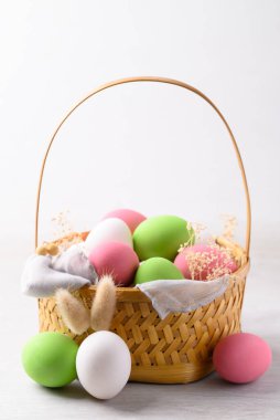 Tavşan kulaklı beyaz paskalya yumurtaları ve beyaz arka planda renkli paskalya yumurtaları.
