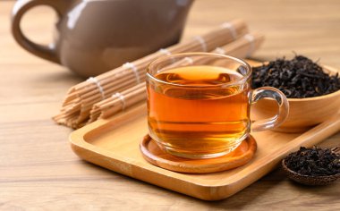 Bardakta siyah çay, kurutulmuş çay yaprakları, sağlıklı bitkisel içecekler.