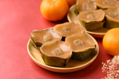 Yapışkan pirinç keki (Nian Gao), Çin Yeni Yıl keki ve kırmızı arka planda portakal meyvesi