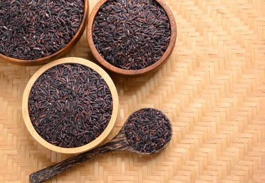 Organik pirinç böğürtlen veya ahşap kasede mor pirinç, kaşık, Tayland pilavı, fotokopi alanı ile üst manzara