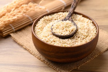 Organik yasemin esmer pirinç tohumu tahta kasede kaşık, Tayland pilavı