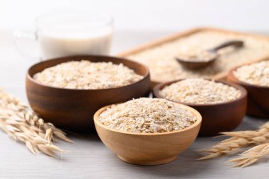 Beyaz arka planda yulaf gevreği ve yulaf sütü, bitkiden yapılan alternatif süt, süt içermeyen.