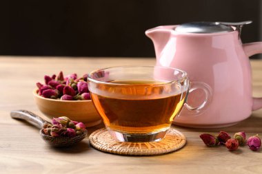 Kurumuş gül tomurcuğu ve siyah bir çaydanlık ile fincanda gül çayı. Sağlıklı çiçek çayı.