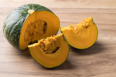 Ahşap arka planda yeşil balkabağı, taze sebze, yiyecek malzemesi.