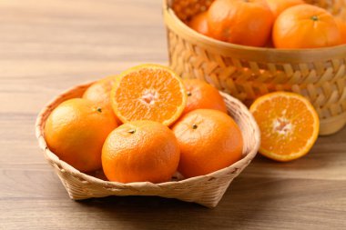 Mandalina portakalı meyve sepeti ahşap arka planda.