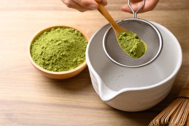 Kiraz yeşili çay tozu elek döküyor. Çayı karıştırmak için hazırlayın.