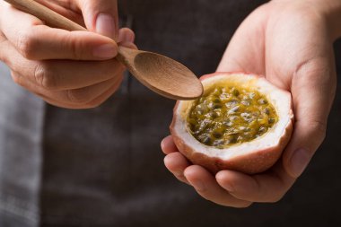 Taze tutku meyvesi, yemek için kaşıkla tutulmuş, tropikal meyve.