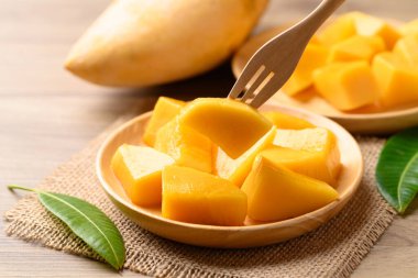 Tahta tabakta küp mango yemeye hazır, yaz mevsiminde tropikal meyve.