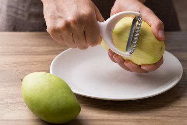 El sıkışma rendesi ve salata yapmak için yeşil mango öğütme.