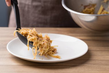 Baharatlı mango salatası kaseye karıştırılır ve tabağa konur.