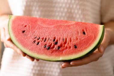 Elle tutulan karpuz dilimleri, yaz mevsiminde tropik meyveler.