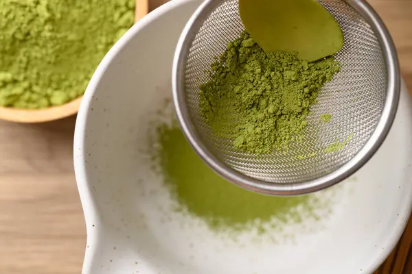 Kiraz yeşili çay tozu elekten dökülüyor. Çay karışımı için hazırlan, Top view.