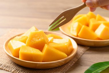 Tahta tabakta dilimlenmiş mango yemeye hazır, yaz mevsiminde tropikal meyve.