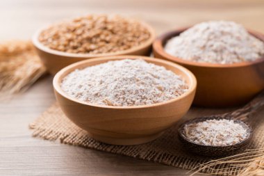 Tahta zemin üzerinde buğday taneli tam buğday unu.