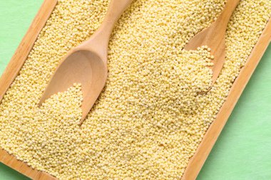 Tahta tabakta sarı darı, kepçeyle, gıda malzemesiyle, üst manzara