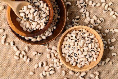 Siyah gözlü bezelye ya da ahşap kasede bezelye kepçeli, yemek malzemeli, üst manzara