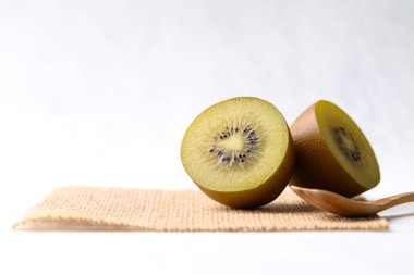 Çuval bezinde taze sungold kivi meyvesi beyaz arka planda ahşap kaşık sağlıklı beslenme