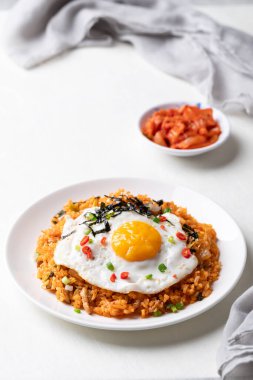 Kızarmış yumurta, domuz eti, susam tohumu, kırmızı biber, taze soğan ve beyaz tabakta deniz yosunu, Kore yemeği.