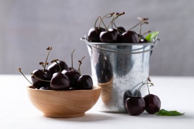 Tahta kasede taze kiraz, beyaz masada kova sağlıklı beslenme ve mevsimsel beslenme.