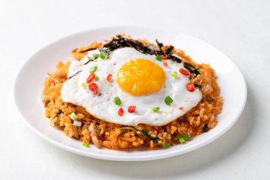 Kızarmış yumurta, domuz eti, susam tohumu, kırmızı biber, taze soğan ve beyaz tabakta deniz yosunu, Kore yemeği.