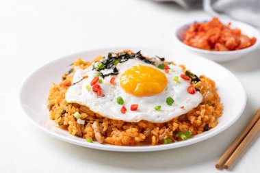 Kızarmış yumurta, domuz eti, susam tohumu, kırmızı biber, taze soğan ve beyaz tabakta deniz yosunu, Kore yemeği.