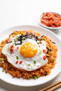 Kızarmış yumurta, domuz eti, susam tohumu, kırmızı biber, taze soğan ve beyaz tabakta deniz yosunu, Kore yemeği.