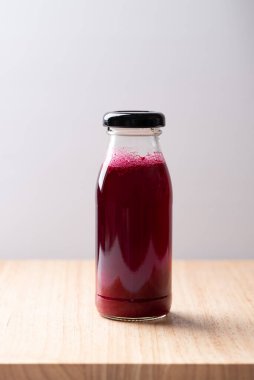 Tahta tahtada şişede taze pancar suyu, sağlıklı bir içecek.