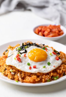 Kızarmış yumurta, domuz eti, susam tohumu, kırmızı biber, taze soğan ve beyaz tabakta deniz yosunu, Kore yemeği.