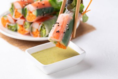 Yengeç sopasıyla salata rulosu, havuç, salatalık ve pirinç kağıdıyla sarılmış salata sosla yenir.